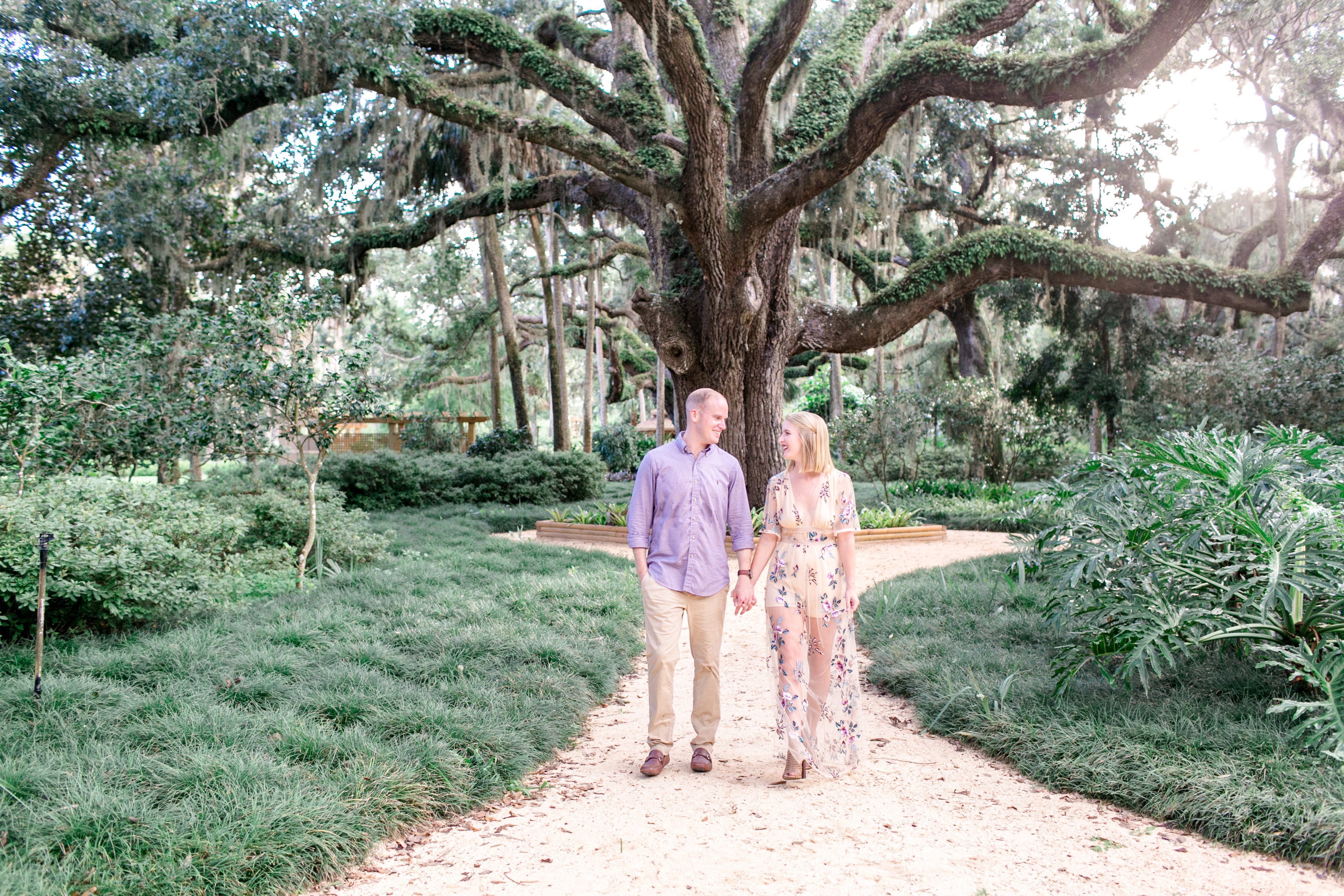 Couple walking trough washington oaks gardens during engagement session